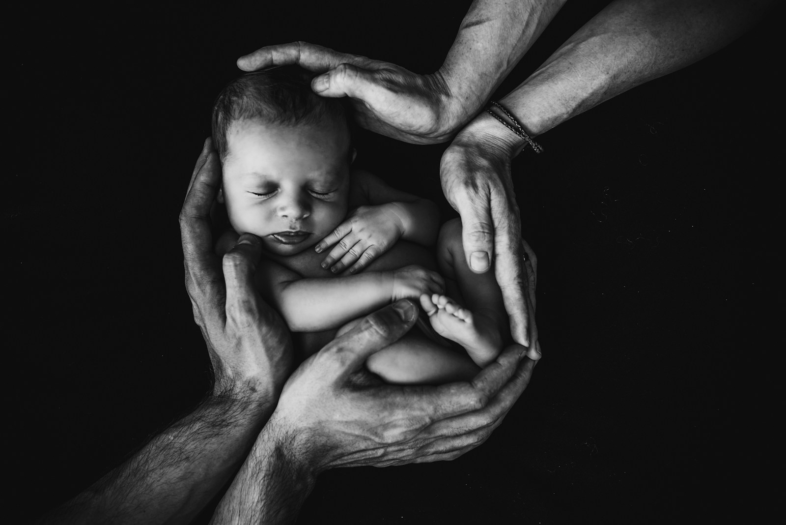 Photo by Isaac Quesada grayscale photo of woman hugging baby