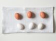 six white and brown eggs on white towel