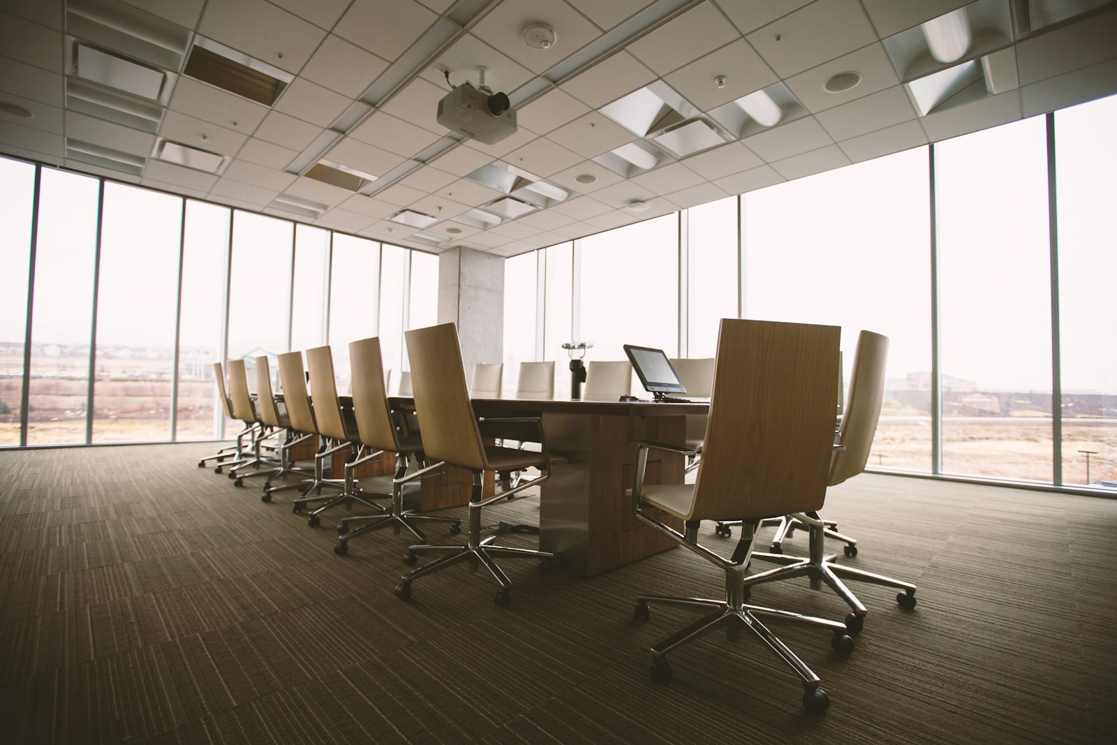 Photo by Benjamin Child oval brown wooden conference table and chairs inside conference room