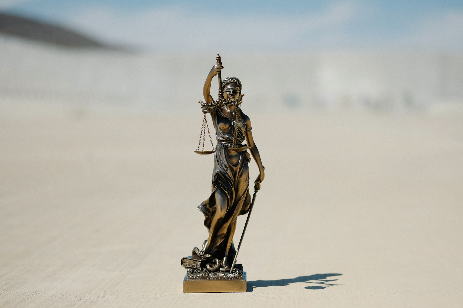 Photo by Wesley Tingey a statue of a lady justice holding a scale