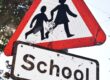 a red and white sign that says school and a black and white sign that says